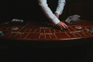 Dealer trực tiếp đang điều hành bàn baccarat trong không gian studio hiện đại